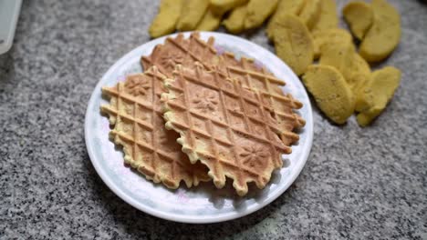 stack of pizzelles, traditional italian waffle cookie served on plate in the kitchen