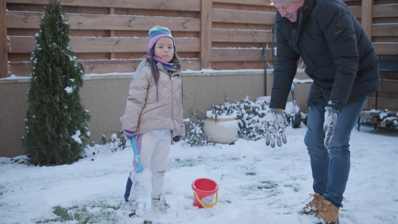 abuelo y nieta divirtiéndose en la nieve