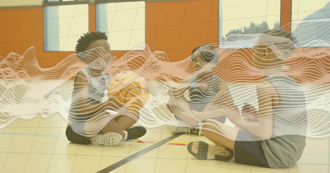 Student in gray shirt initiating passing by tossing orange basketball across gym floor for sports