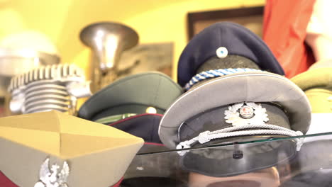 panoramic of world war military hats and helmets in antique shop in warsaw old town 4k