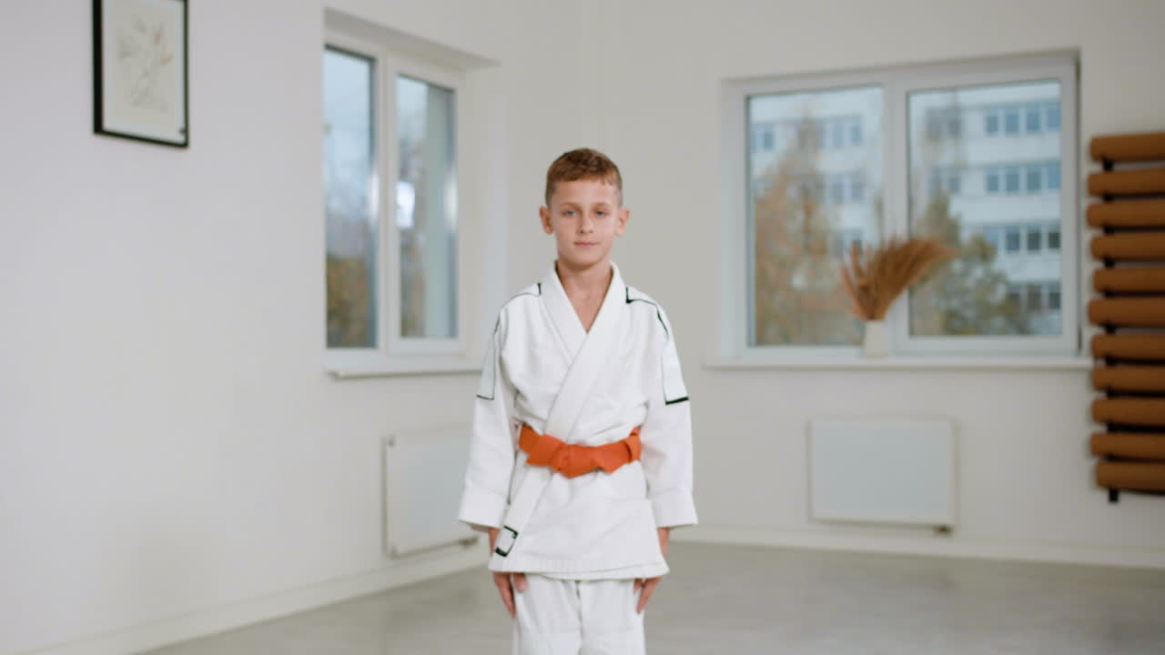 niño en kimono blanco en la clase de artes marciales