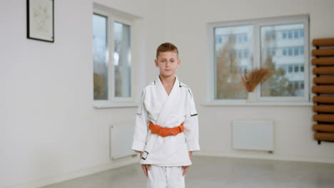 boy in white kimono in martial arts class