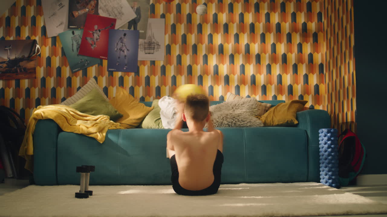 Child doing sit-ups with a medicine ball in a home gym.