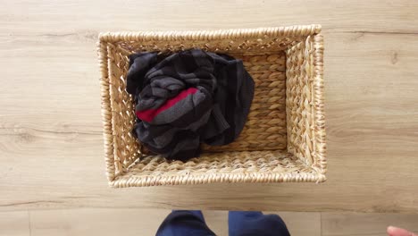 a person folding clothes and putting them in a basket