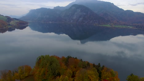 Toma-Aérea-De-Un-Lago-Con-Un-Paisaje-Alpino-En-El-Fondo,-4k-Uhd