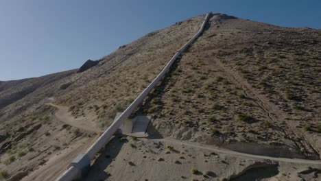 vista aérea del oleoducto del acueducto de california moviéndose cuesta arriba