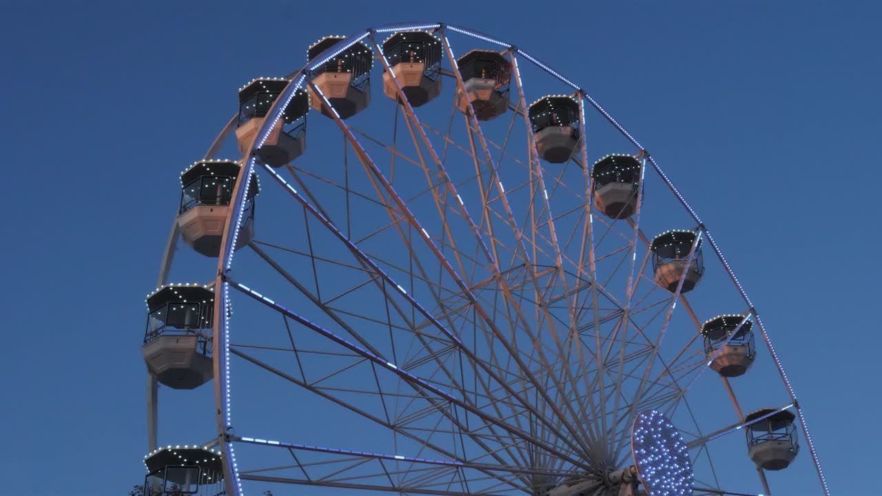 la rueda gigante en acción contra un cielo azul.