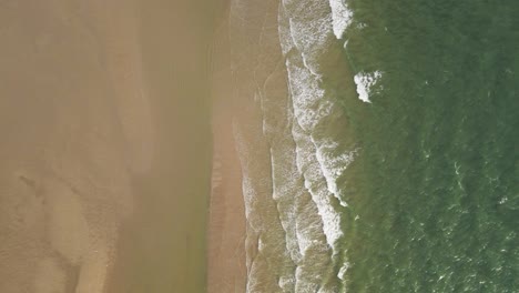 Antena-Arriba-Hacia-Abajo:-Olas-De-Océano-Cristalino-Que-Llegan-A-La-Playa-De-Arena-Durante-La-Luz-Del-Sol