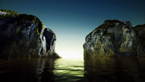 Rugged cliffs reflect sunset over tranquil waters at coastal inlet