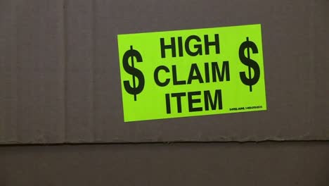 high claim item sticker on the side of a cardboard box shipping package