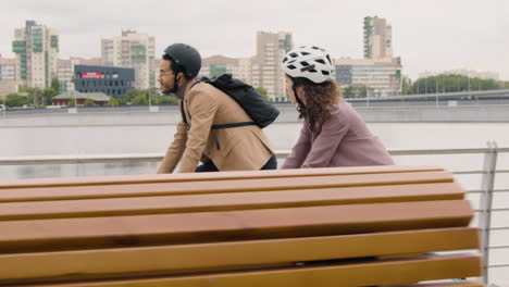 american man and woman riding bikes and talking to each other while going to work 2