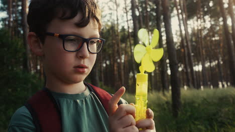 niño jugando con juguete en el bosque