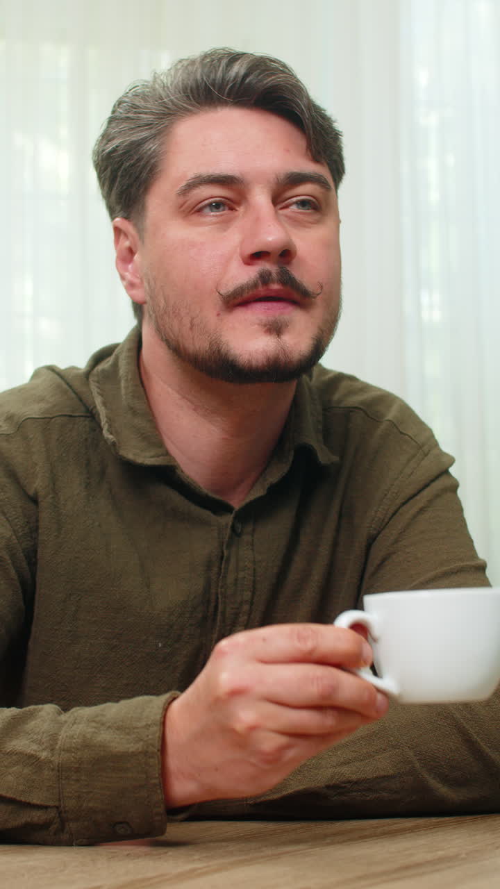 Middleaged man enjoying peaceful coffee moment sipping warm beverage calmly smiling at table desk