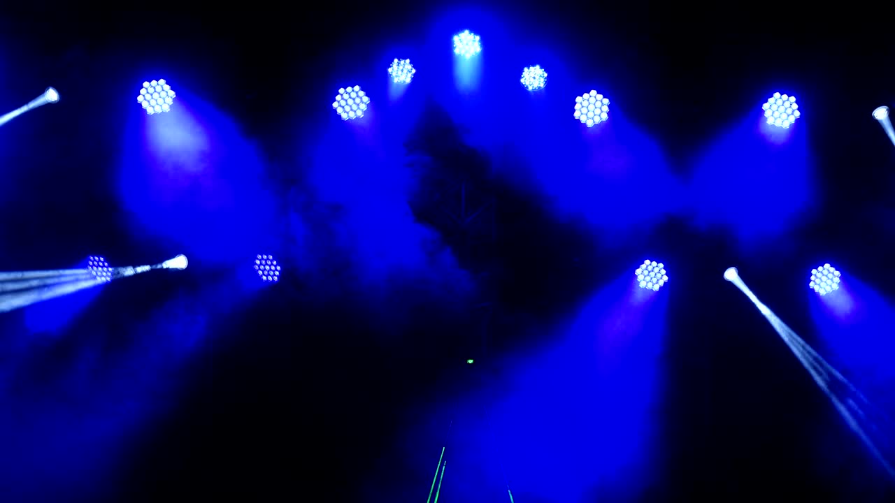Bright flashing concert spotlights lasers and smoke at the scene background