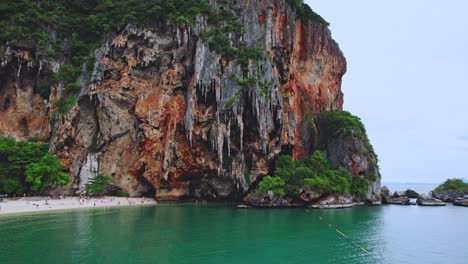 Playa-De-Phra-Nang-En-Railay-Con-Escarpados-Acantilados-De-Piedra-Caliza-Desde-Un-Dron-Aéreo-Inclinándose-Hacia-Las-Rocas