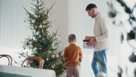 father and young son decorating tree unpacking christmas decorations