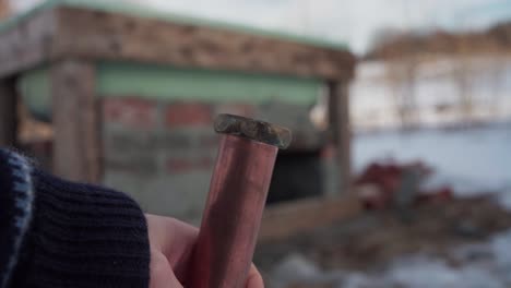 the man is examining the pipe intended for the construction of the diy hot tub - close up