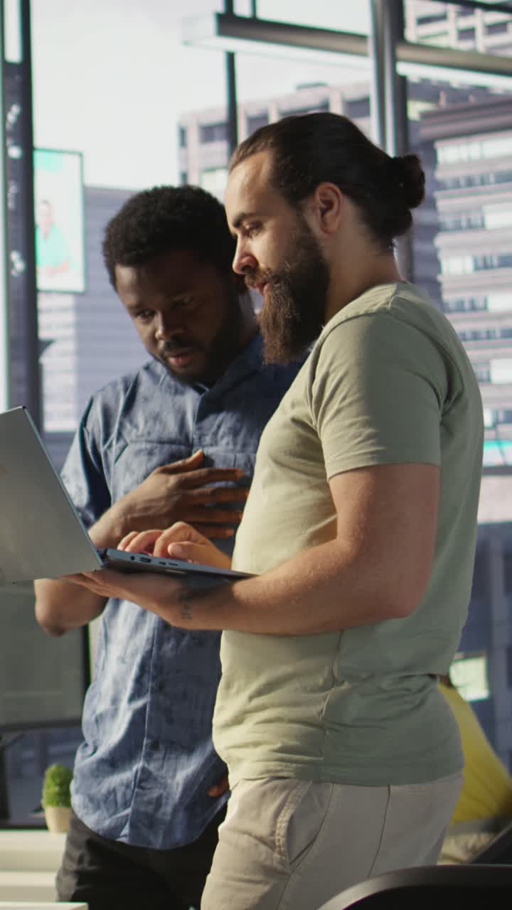Vertical video Developer and colleague checking code on notebook, doing brainstorming
