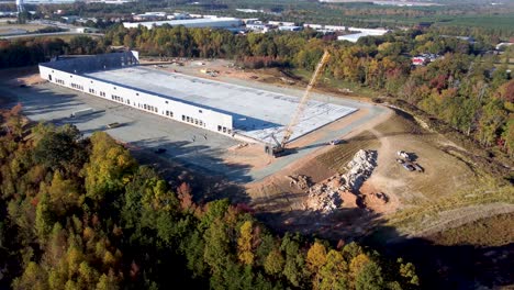 A-medium-wide-drone-shot-of-a-heavy-duty-crane-moving-into-position-at-a-construction-site