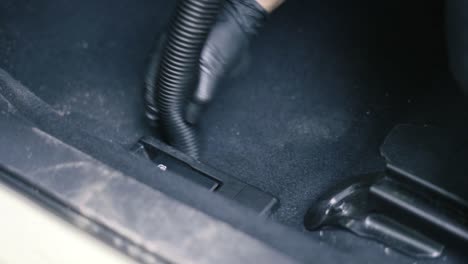 Close-up-of-a-male-wearing-black-gloves-vacuum-an-black-interior-car