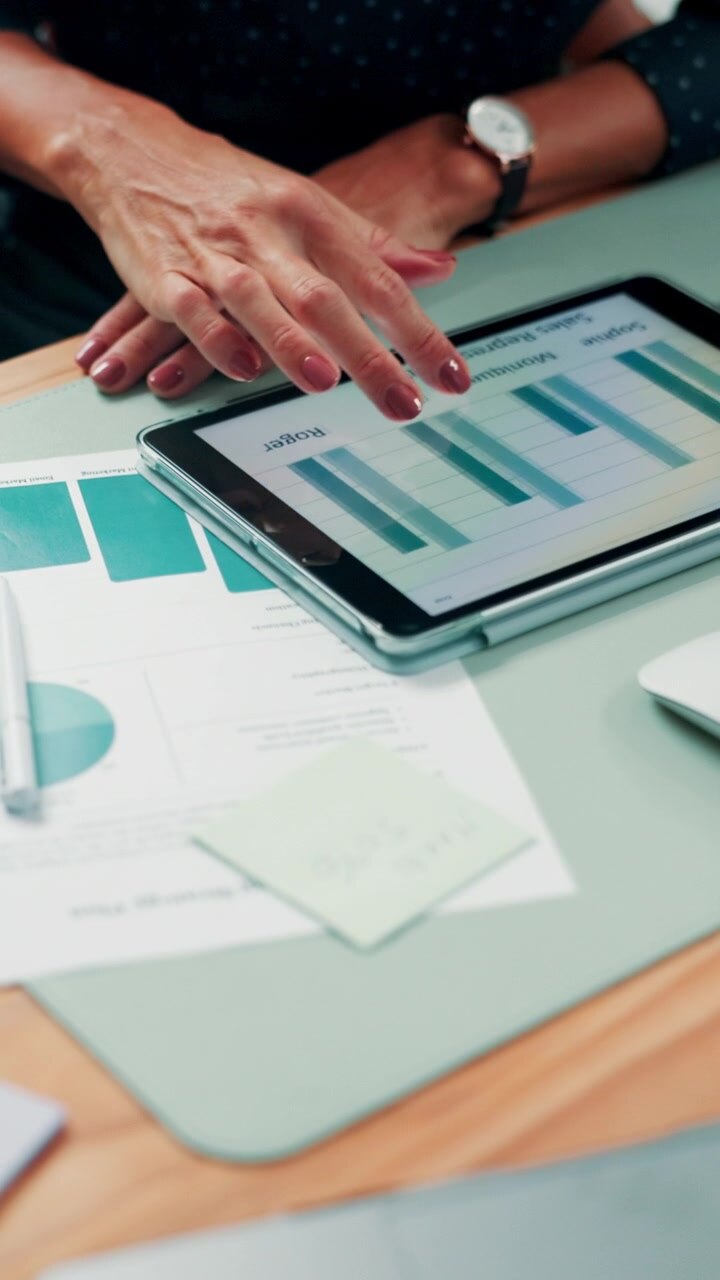 Forretningskvinde analyserer salgsdata på digital tablet på kontoret