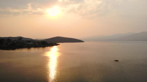 aerial view of happy couple kayaking into a scenic sunset on a tranquil lake