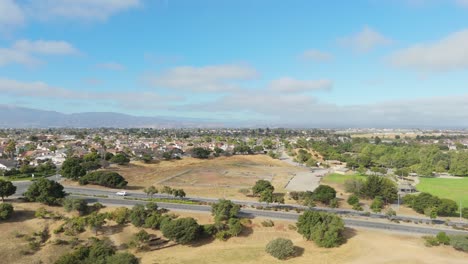 drone establishing above fields and trails in natividad park with sunny weather and clear skies, suburban park