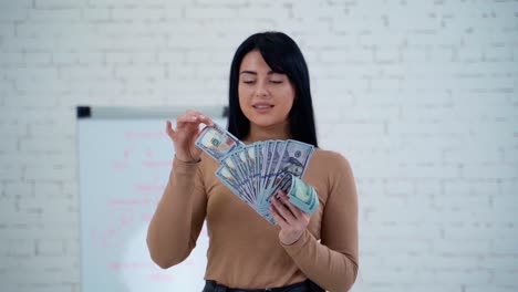 woman holding money banknotes. portrait of a cheerful young woman holding money banknotes