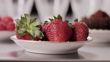 camera reveals tasty strawberry on a plate with dolly movement on the kitchen table close-up shoot