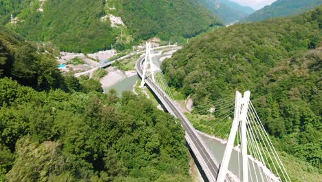 aerial view of a cable-stayed bridge over a river in a mountainous landscape