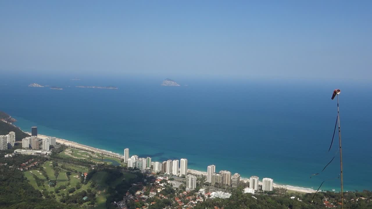 Windsock In Seaside City Of Rio de Janeiro In Brazil With Overview Of Beachfront Hotel Buildings And Wide Blue Sea In Background. high angle