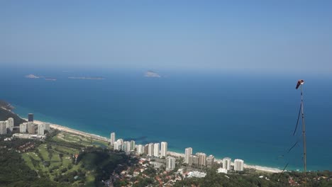 windsock in seaside city of rio de janeiro in brazil with overview of beachfront hotel buildings and wide blue sea in background. high angle