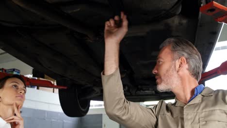 mecánico mostrando al cliente el problema con el coche