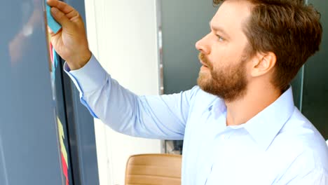 arquitecto masculino poniendo notas adhesivas en vidrio 4k