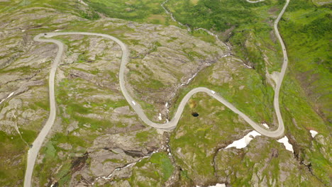 Vista-Aérea-De-Los-Vehículos-Que-Circulan-Por-La-Sinuosa-Carretera-De-Eidsdal-A-Geiranger-En-Noruega.