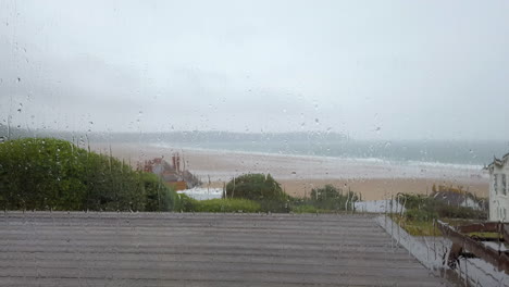 Statische-Aufnahme-Von-Regentropfen,-Die-Ein-Fenster-Mit-Meerblick-Herunterfallen