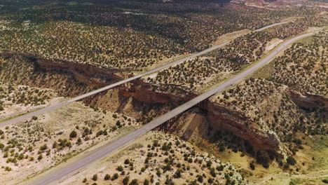 Huge crack in the rocks of desert in Utah, USA. Bridges connecting the sides of a split for transport to pass. Aerial view.