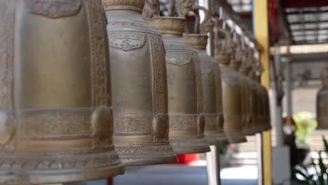 the big metal bells hanging in the row inside thai temple