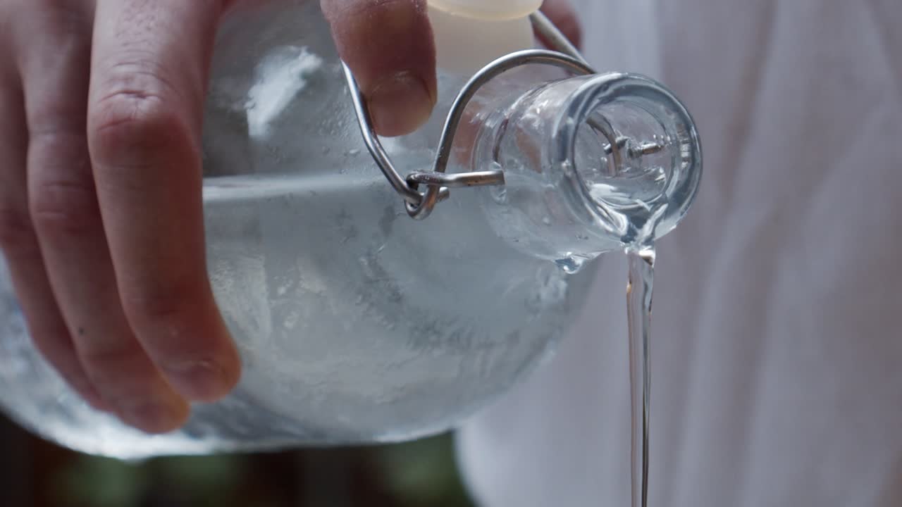 유리병에서 차가운 물을 붓는 요리사