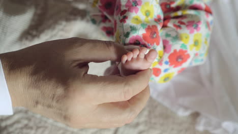 Abuelo-Sosteniendo-El-Pie-Pequeño-Del-Nieto-Del-Bebé