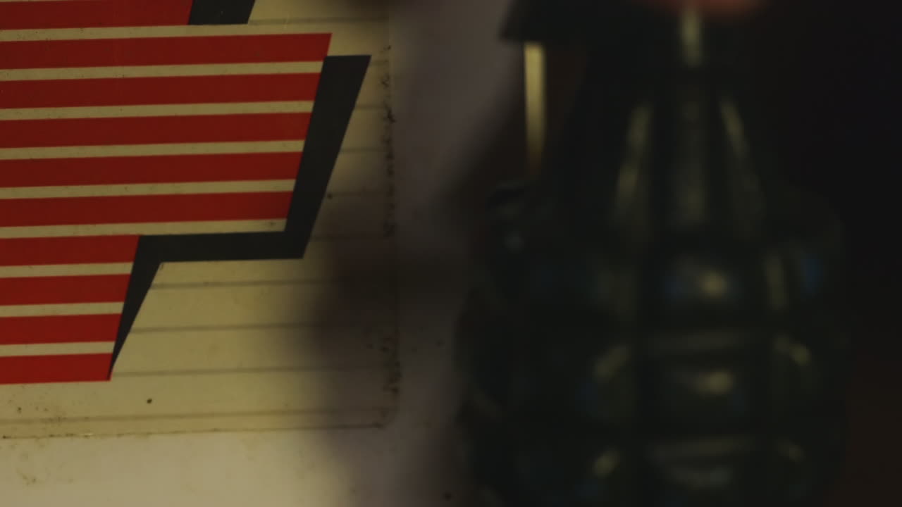 Unidentifiable Hand Places Toy Grenade Next to First Aid Kit, Close Up