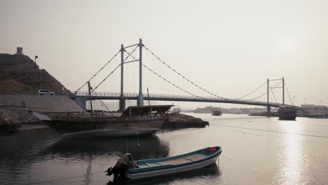 parked boats in front of a bridge