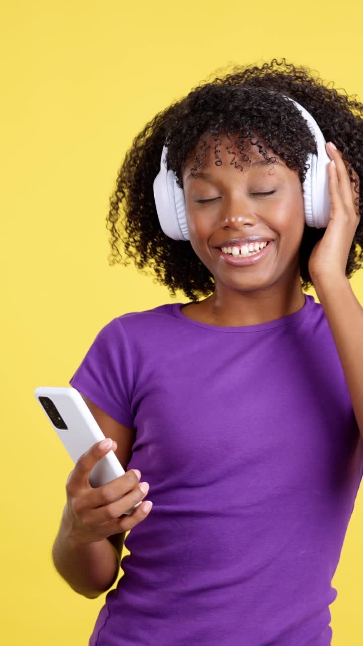 Giovane donna con le cuffie che ascolta musica sullo smartphone