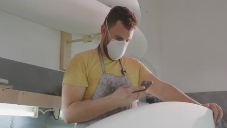 Male-surfboard-maker-in-his-workshop