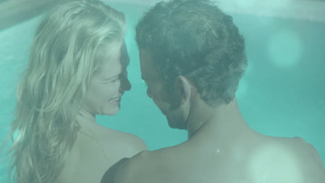 in swimming pool, couple relaxing and embracing, sharing joyful animation together