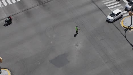 santo domingo, dominican republic - april 2023 - traffic officer stopping a vehicle trying to cross at a red light, drone view in the city of santo domingo, dominican republic