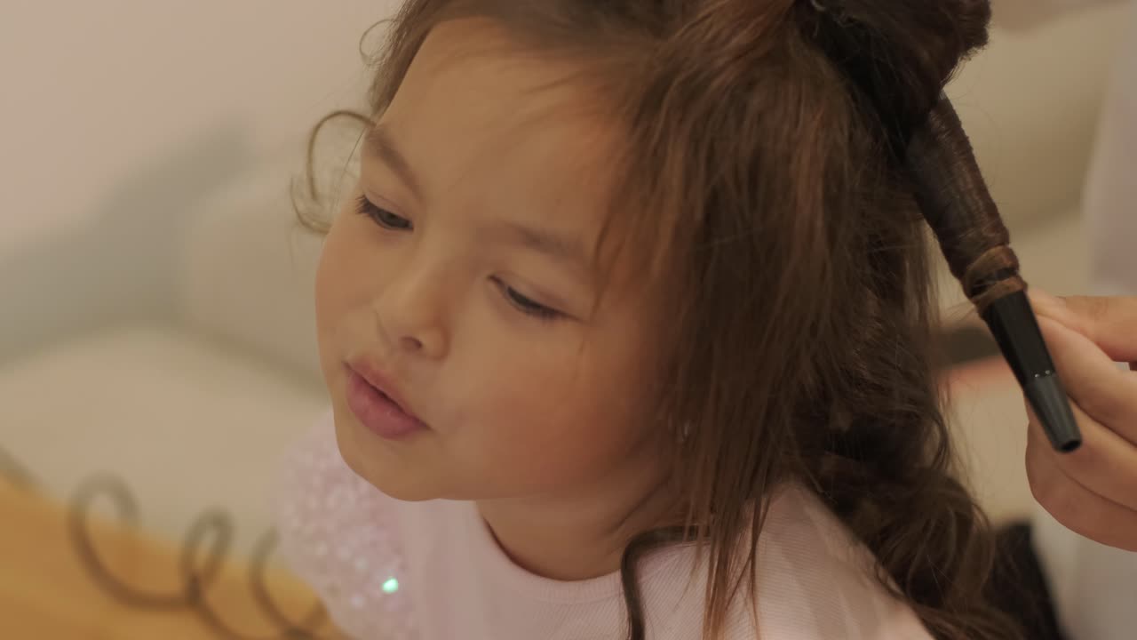 임신 한 어머니 가 집 에서 딸 의 머리 를 꾸미고 있다