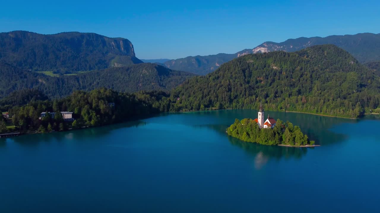 Aerial drone video Mountains fold into the background behind Lake Bled and Lake Bled Island