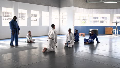 practicing judo, athletes training on mats in martial arts dojo