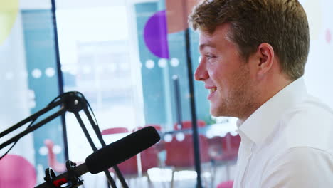 young man broadcasting podcast in a studio, close up